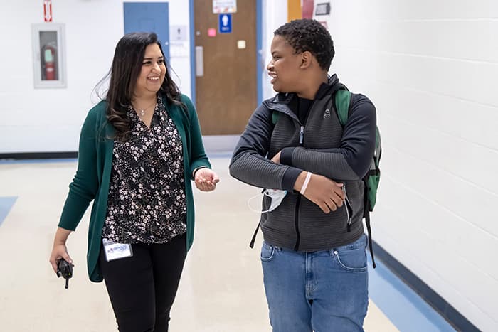 Faria Nazrul walks down an OMMS hallway with a male student.