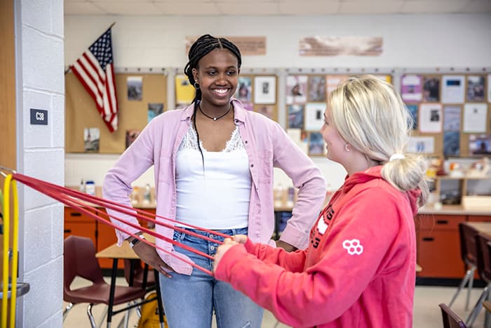 Mia Swaby-Rowe works with a fellow student to use arm bands.