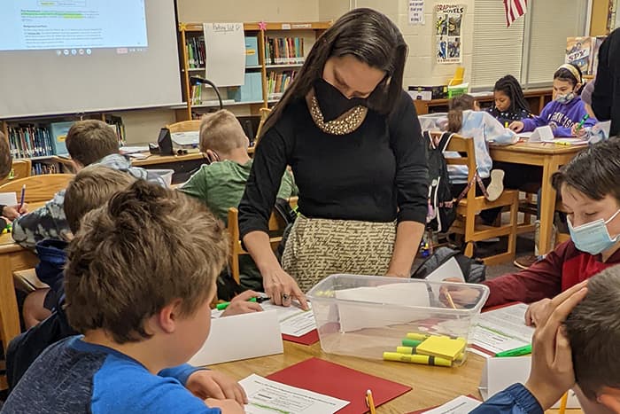 Stephanie Hastings works with a group of students who are reviewing written materials.