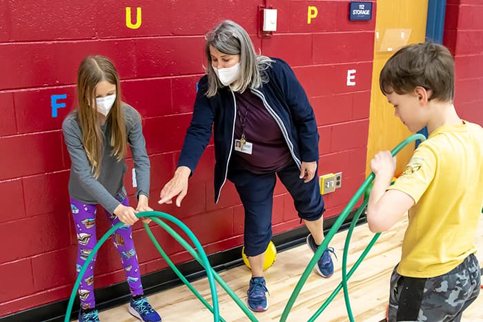 Kathy Eckley shows a student how to make a hula hut.