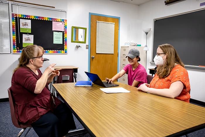 Carolyn Torsiello uses American Sign Language to interpret a teacher's directions for a hard of hearing student.