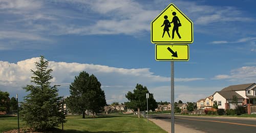 Pedestrian walk sign along a road.