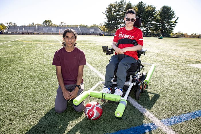 Amitav Kohl and Ryan Kobylski on the soccer field with the device Amitav created for Ryan.
