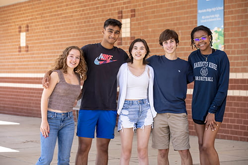 A group of five high school students standing shoulder to shoulder.