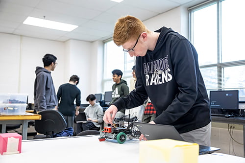 A male student working on a robotics project.