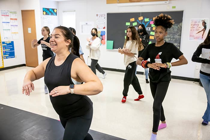 BBMS dance teacher demonstates a dance move to her class