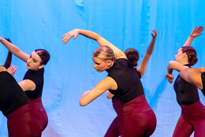 A group of female dance students holding their arms in a pose. 