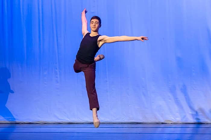 A male dance student leaping in the air.