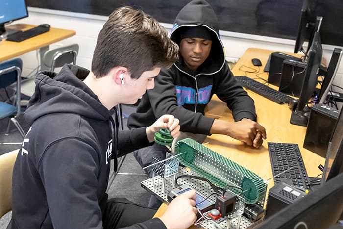 Two WLHS students working to construct an automated assembly line.