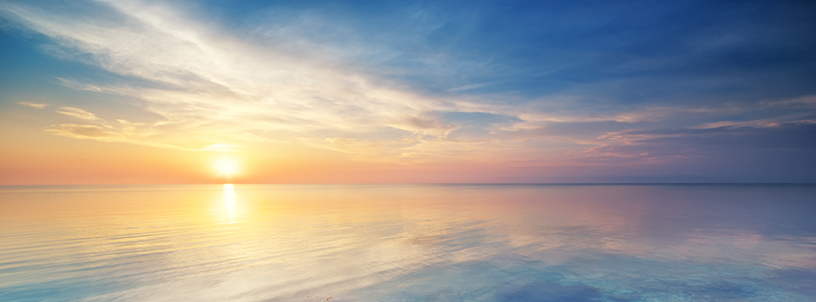 Pastel sunset over the ocean in a cloudy sky