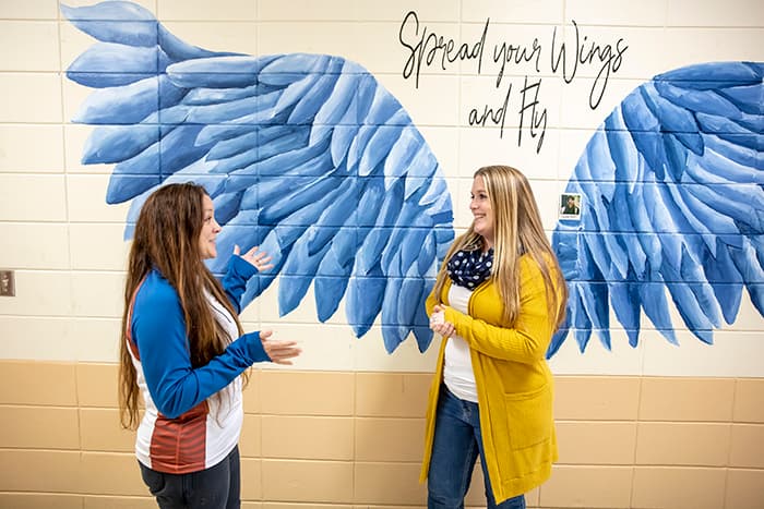 Amy Miller and Homewood Assistant Principal Laura Peter stand in front of a mural.