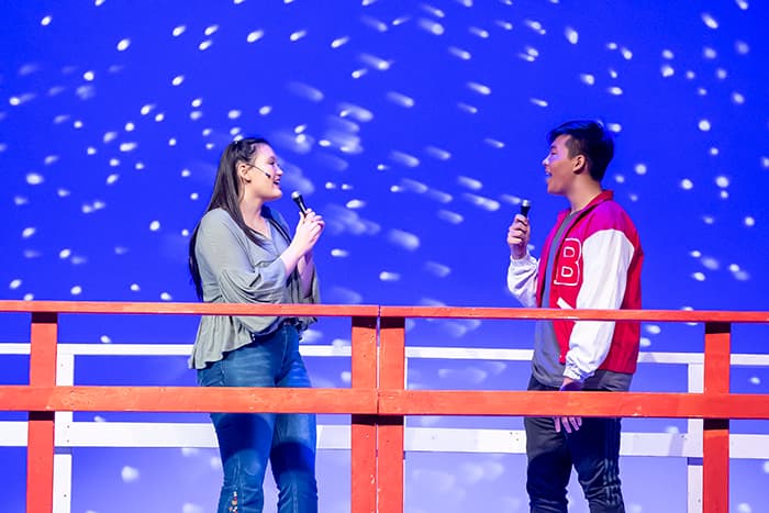 A male and female RHHS student singing to each other onstage.