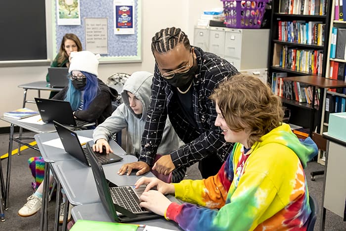 Miles Blount talking to a student about a computer-based activity.