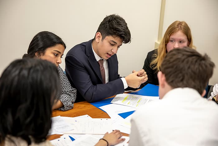 A group of students reviews and discusses evidence to support their argument during the Middle School G/T Debate.