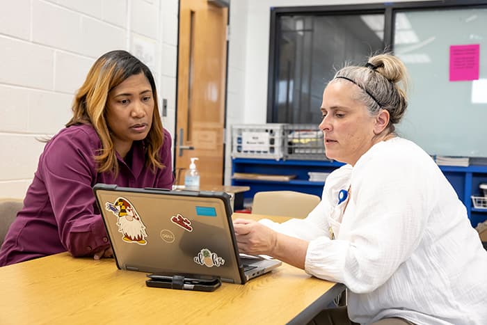 Diedre Hill and Kellie Frey review and discuss students' reading progress.