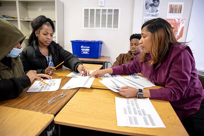 Reading Specialist Diedre Hill works with a small group of students on a reading activity.