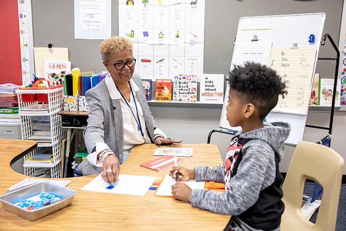 Reading Specialist Camille Washington works with a male student.