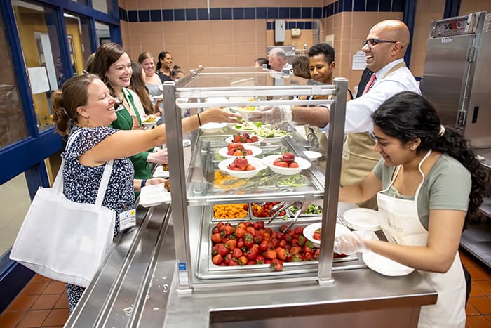 Administrators serving lunch to new staff at NEO.