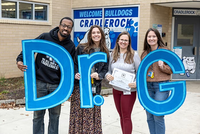 CRES staff outside CRES holding letters that spell "Dr. G."