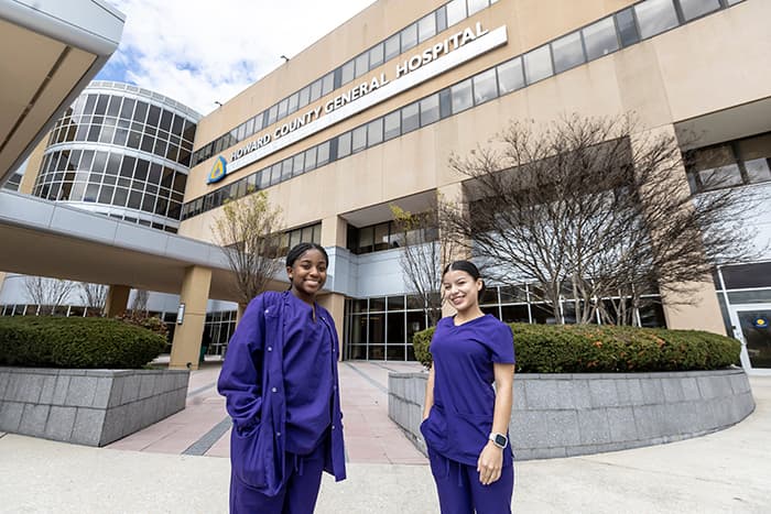 Two Academy of Health Professions students standing outside Howard County General Hospital.