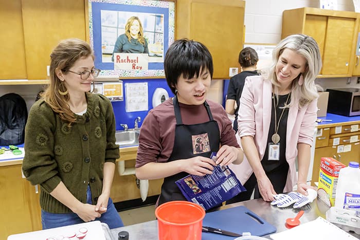 Annette Bartlett (right) works with a student and a teacher in the Soup to Nuts cooking club.