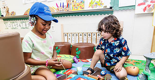 Two small children playing in a classroom.