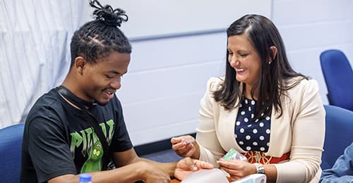 Barbara Baker helping a student with a project.