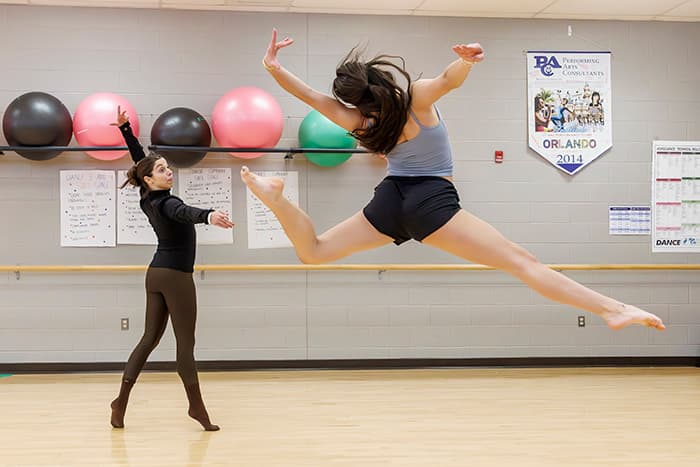 A CHS dance student leaping and Haley Nachlas dancing along side her.