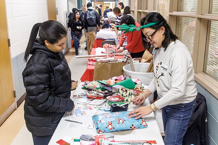 A Grace Church volunteer working with a Homewood student at the Homewood Treasure Sale.