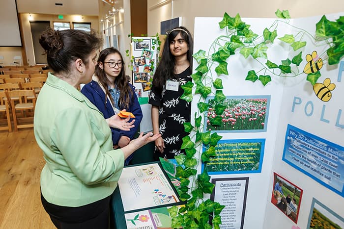 Amy Reese speaking with students about their Climate Summit poster.