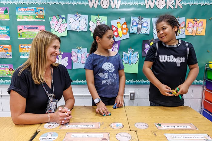 Alesia Richter smiling at two students.