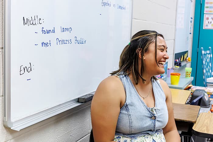A Department of Special Ed staffperson smiling in a classroom.
